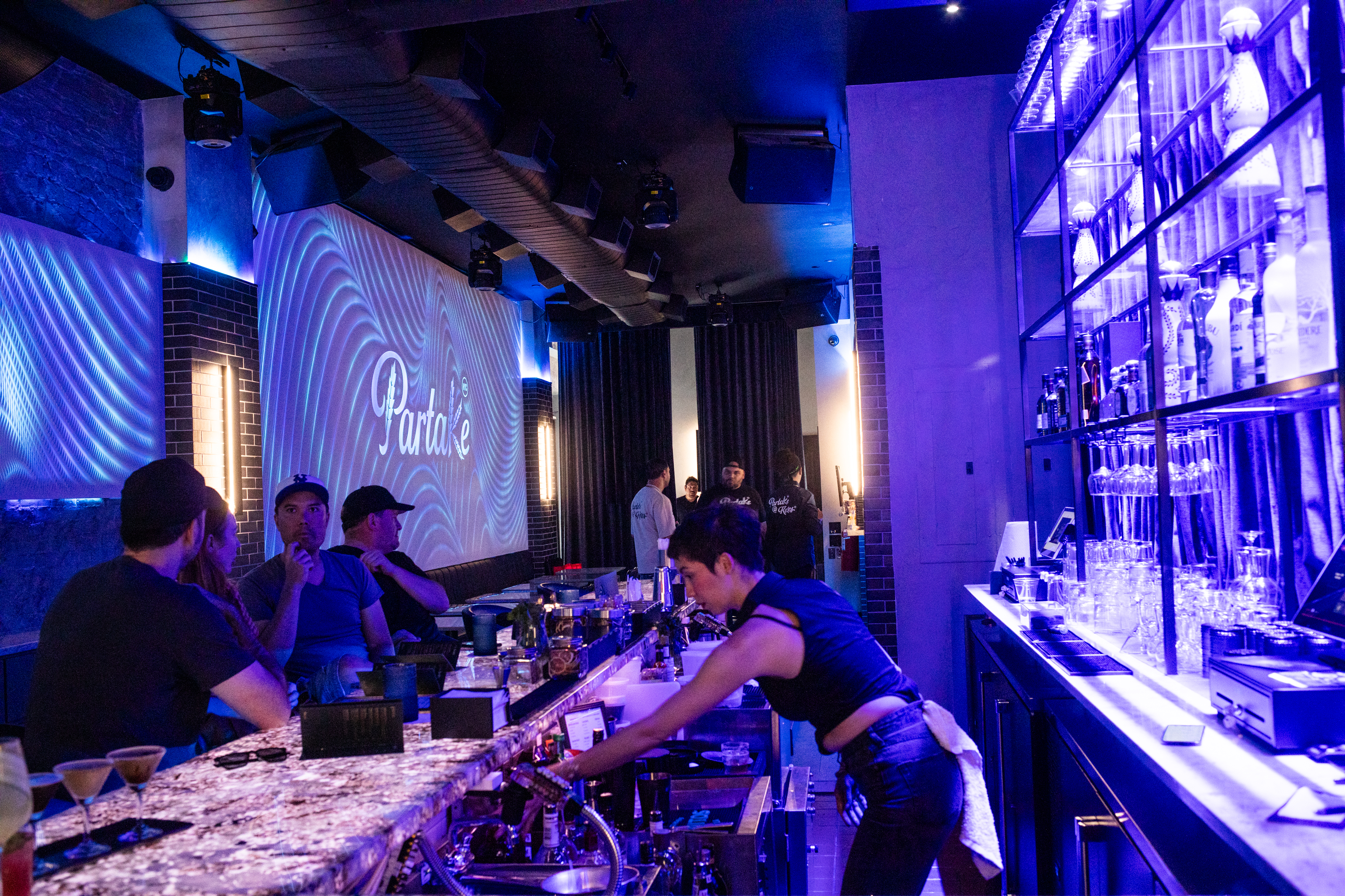 The main bar at Partake NYC, lit under the marquee